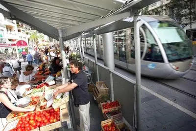 a train is pulling into a market with people at a fruit stand at Appartement Terrasse Quartier Liberation in Nice
