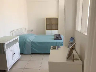 a room with a bed and a table with a television at Appartement Terrasse Quartier Liberation in Nice