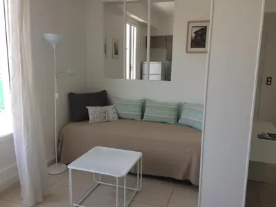 a bedroom with a bed with a mirror and a table at Appartement Terrasse Quartier Liberation in Nice