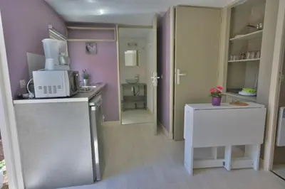 a small kitchen with a microwave and a refrigerator at Camping Les Cent Chênes in Saint-Jeannet