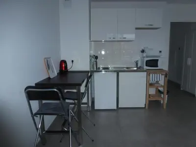 a kitchen with white cabinets and a table and chairs at beau studio in Nice