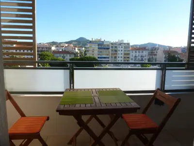 a table and two chairs on a balcony with a view at beau studio in Nice