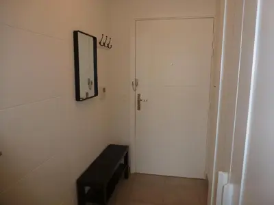 a hallway with a door and a bench and a mirror at beau studio in Nice