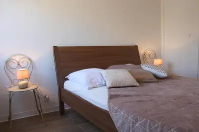a bedroom with a bed with two lamps on a table at Le Renoir in Nice