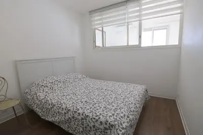 a white bedroom with a bed and a window at Le Renoir in Nice