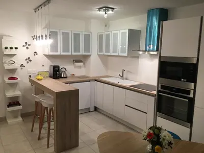 a kitchen with white cabinets and a counter top at Riviera Terrasse - parking gratuit in Nice