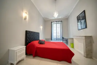 a bedroom with a red bed in a white room at Lusso 5 beds Central Apartment in Nice