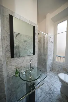 a bathroom with a glass sink and a shower at Lusso 5 beds Central Apartment in Nice