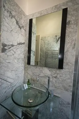 a bathroom with a glass sink and a mirror at Lusso 5 beds Central Apartment in Nice