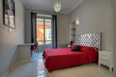 a bedroom with a red bed and a window at Lusso 5 beds Central Apartment in Nice