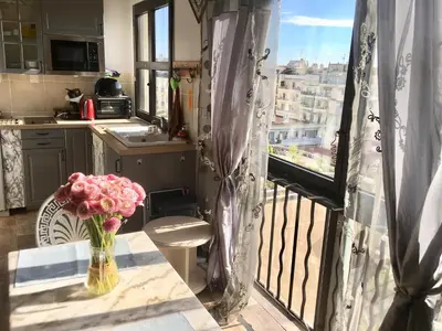 a kitchen with a vase of flowers on a table with a balcony at Luxurious Studio in NICE 450 m of the sea in Nice