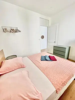 a bedroom with a large bed with pink sheets at Promenade des Anglais panoramic sea view in Nice