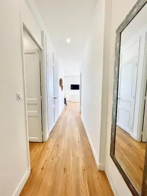 a hallway with white walls and a mirror at Promenade des Anglais panoramic sea view in Nice