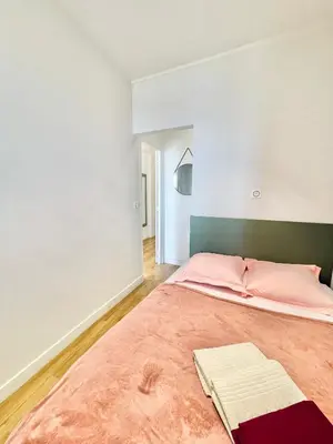 a bedroom with a large bed with pink sheets at Promenade des Anglais panoramic sea view in Nice