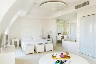 a white bedroom with a bed and a mirror at Boscolo Nice Hotel & Spa in Nice
