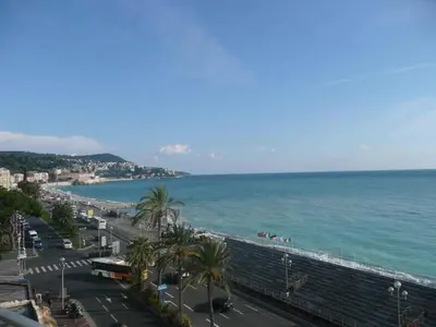 a view of the ocean and a beach with palm trees at Parc Anahit in Nice