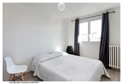 a bedroom with a bed and a chair and a window at Parc Anahit in Nice