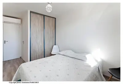 a white bedroom with a bed and a closet at Parc Anahit in Nice