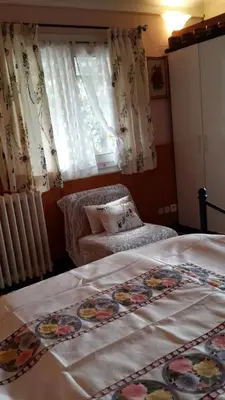 a bedroom with a bed and a chair and a window at Lovely house in Cagnes-sur-Mer