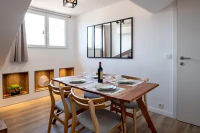 a dining room with a table with chairs and a mirror at 