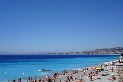 a group of people on a beach with blue water at 