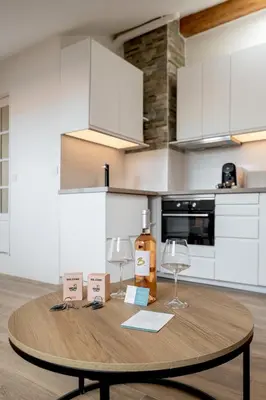 a wooden table in a kitchen with a bottle and glasses at 