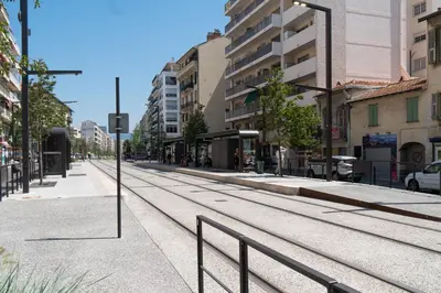 an empty street with train tracks in a city at Top Floor Apartment Santa Barbara in Nice