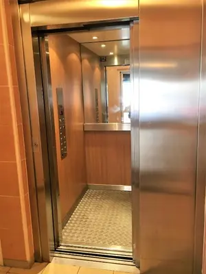 an elevator in a hotel room with a mirror at Top Floor Apartment Santa Barbara in Nice