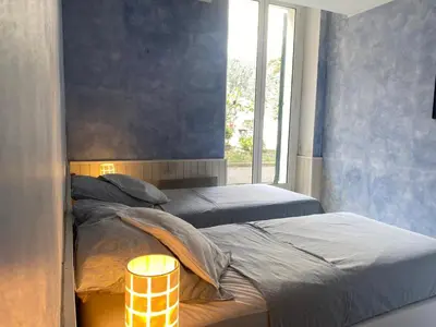 two twin beds in a room with a window at Apartment Villa Anahit in Nice
