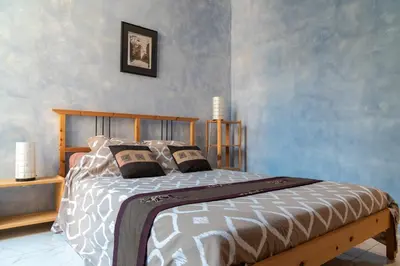 a bedroom with a bed with a wooden head board at Apartment Villa Anahit in Nice