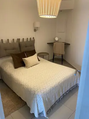 a bedroom with a large bed and a table at Au cœur de St Jean Cap Ferrat in Saint-Jean-Cap-Ferrat