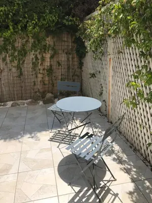 a white table and two chairs and a fence at Au cœur de St Jean Cap Ferrat in Saint-Jean-Cap-Ferrat