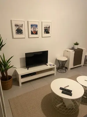 a living room with a flat screen tv on a white entertainment center at Au cœur de St Jean Cap Ferrat in Saint-Jean-Cap-Ferrat