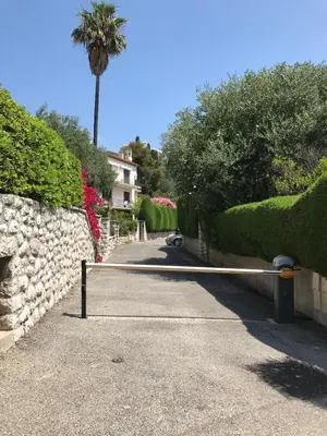 a road with a fence and a palm tree at Au cœur de St Jean Cap Ferrat in Saint-Jean-Cap-Ferrat