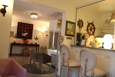 a living room with two chairs and a mirror at Hôtel La Villa des Oliviers in Cagnes-sur-Mer