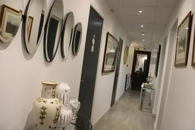 a hallway with vases on the wall and pictures on the wall at Hôtel La Villa des Oliviers in Cagnes-sur-Mer