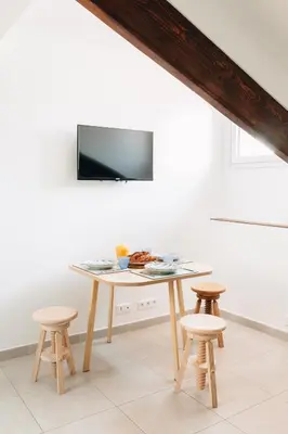 a table with four chairs and a tv on a wall at Adorable apartment in Nice downtown in Nice