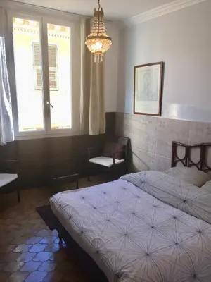 a bedroom with two beds and a chandelier and a window at Niceaparts in Nice