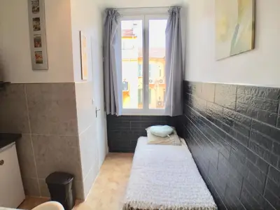 a small room with a window and two beds at Niceaparts in Nice