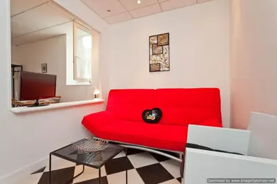 a red couch in a living room with a table at Beach, Pure Centre, view over Opera de Nice in Nice