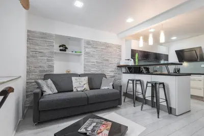 a living room with a couch and a kitchen at Amazing 3 Bdrs and Garden Place du Pin Parking ! in Nice