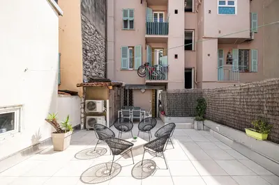 a patio with chairs and a table on a building at Amazing 3 Bdrs and Garden Place du Pin Parking ! in Nice