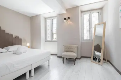 a bedroom with a bed and a mirror and a chair at Amazing 3 Bdrs and Garden Place du Pin Parking ! in Nice