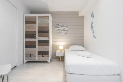 a small bedroom with two beds and a table at Amazing 3 Bdrs and Garden Place du Pin Parking ! in Nice