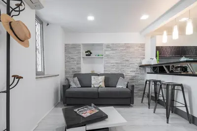 a living room with a couch and a kitchen at Amazing 3 Bdrs and Garden Place du Pin Parking ! in Nice