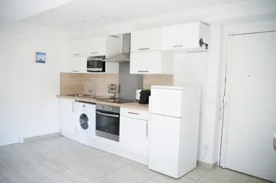 a kitchen with white cabinets and a washer and dryer at Sunny apartment in heart of Nice Old Town in Nice