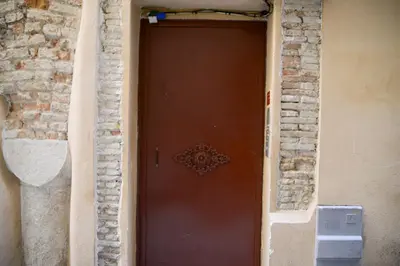 a brown door in a building with a brick wall at Sunny apartment in heart of Nice Old Town in Nice