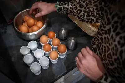 a woman is standing next to a bowl of eggs at Nemea Appart Hotel Le Lido Cagnes sur Mer in Cagnes-sur-Mer