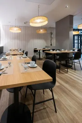 a conference room with tables and chairs and chandeliers at Nemea Appart Hotel Le Lido Cagnes sur Mer in Cagnes-sur-Mer