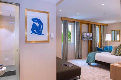 a hotel room with a bed and a bathroom at Hotel Beau Rivage in Nice